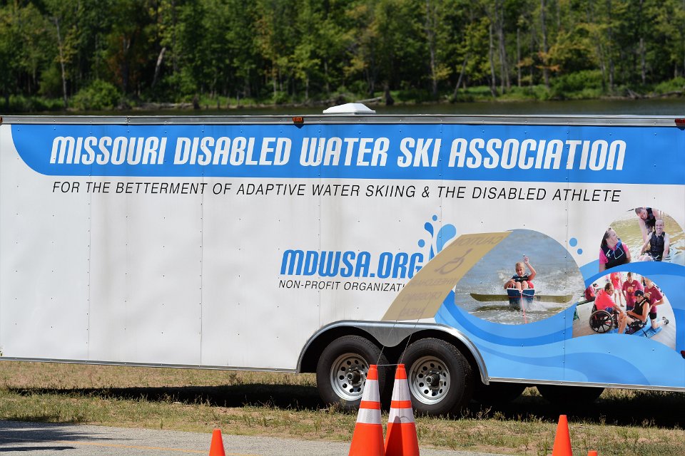 MDWSA equipment trailer has 3 photos on it; one of a sit skier in action, one of a skier having fun hanging out in the shallow part of the lake and one of a skier getting fitted for his ski equipment