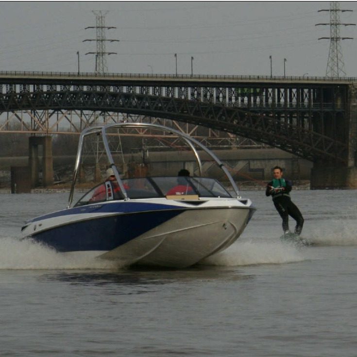 a white and blue boat pulling a skier on the Mississippi River
